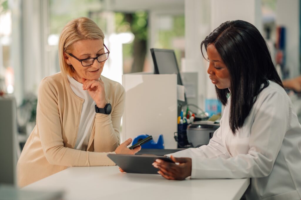 A provider and patient smile and discuss menopause skin care in Denville