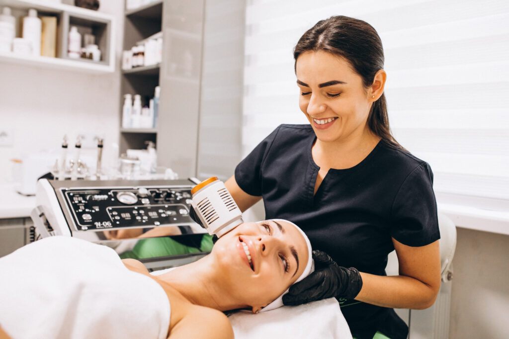 An Exhibit Medical Aesthetics provider applies a chemical peel to a patient's face as an acne scar treatment in Denville.