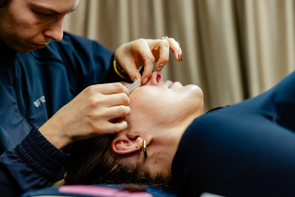 patient lies on side as nurse covers her eyes