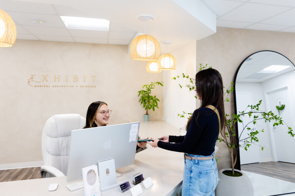 Photo of woman returning tablet to the receptionist in Exhibit lobby