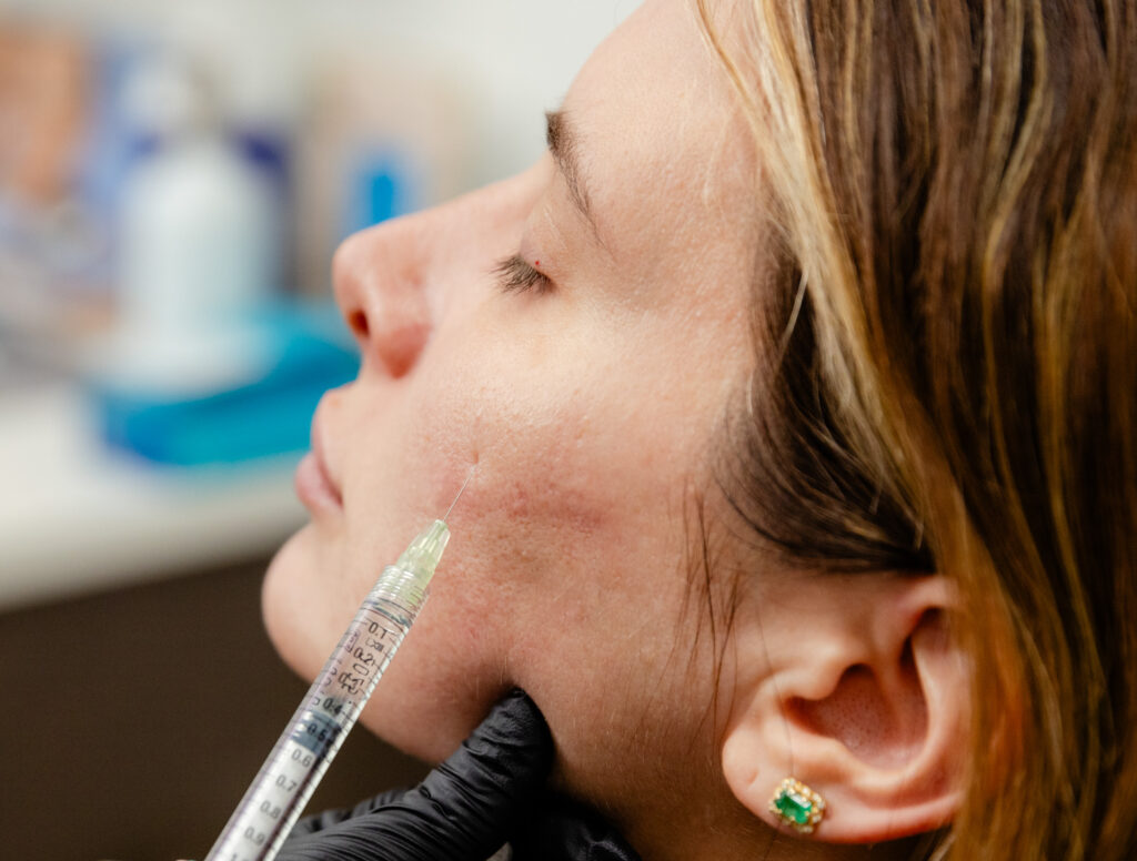 Photo of woman with needle in cheek