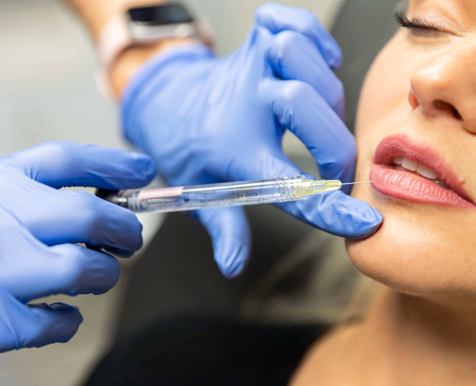 Close up of needle in woman's lip.