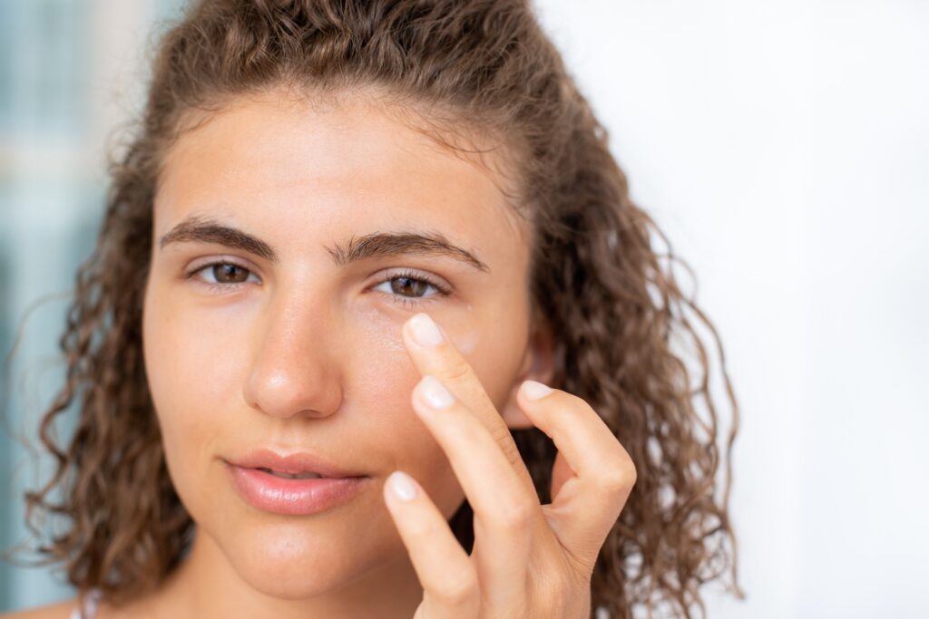 Photo of woman with her hand up near her eye.