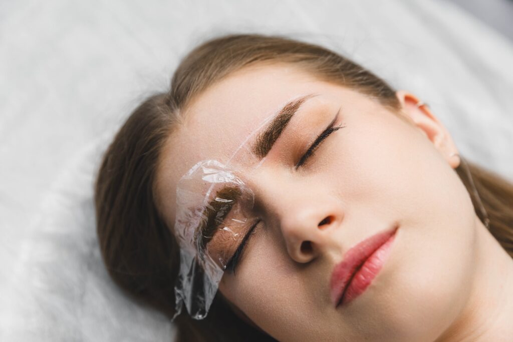 Woman lying down with plastic over one eye.