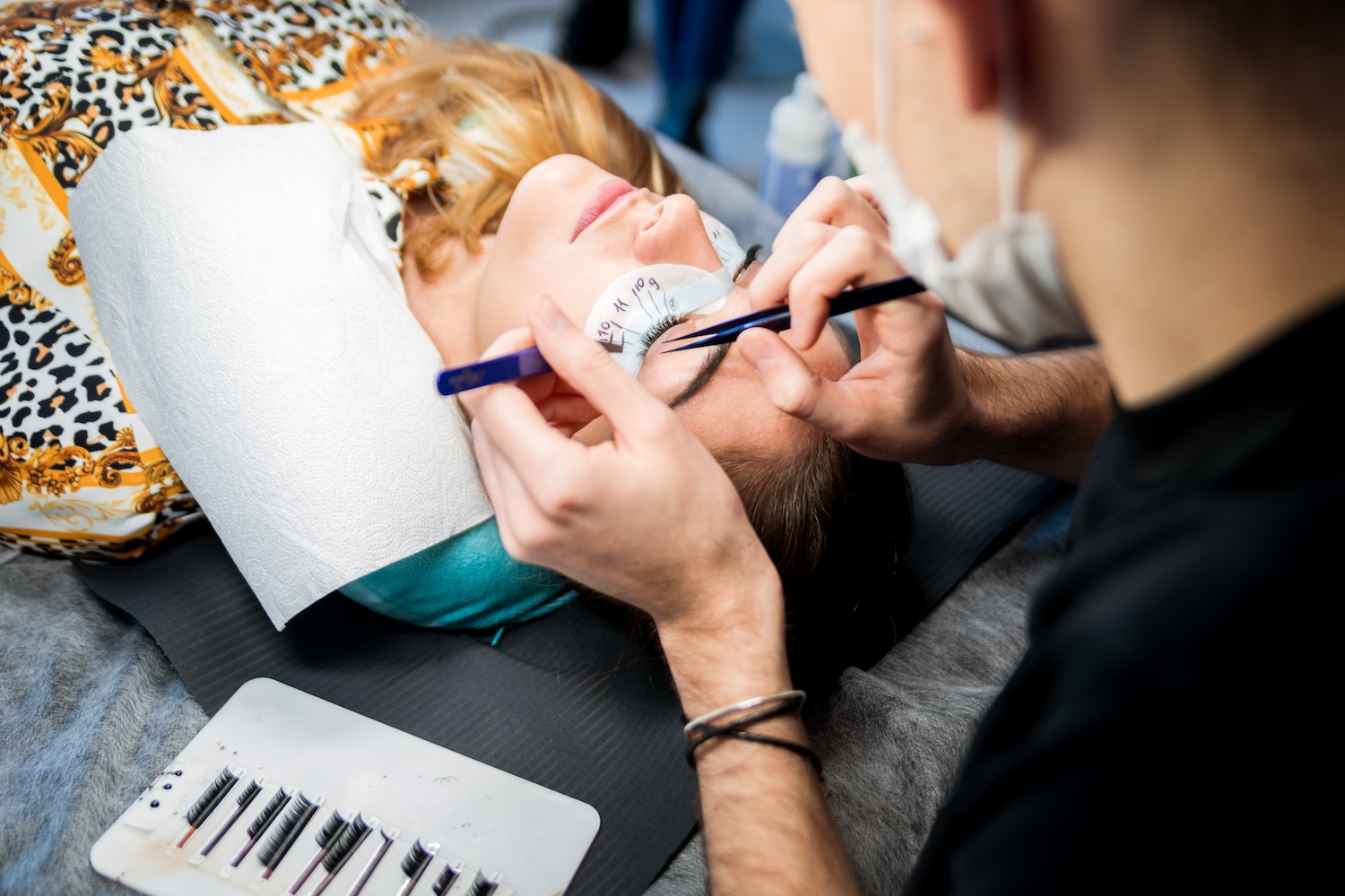 Patient receiving eyelast extension at beauty salon