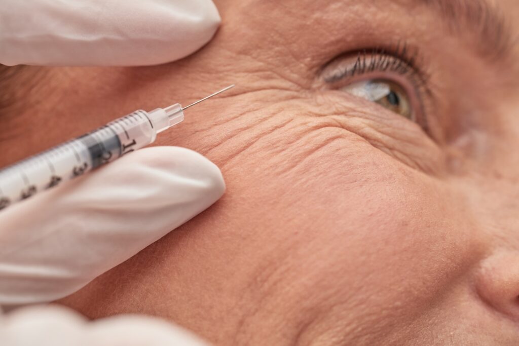 side angle of needle next to man's face.