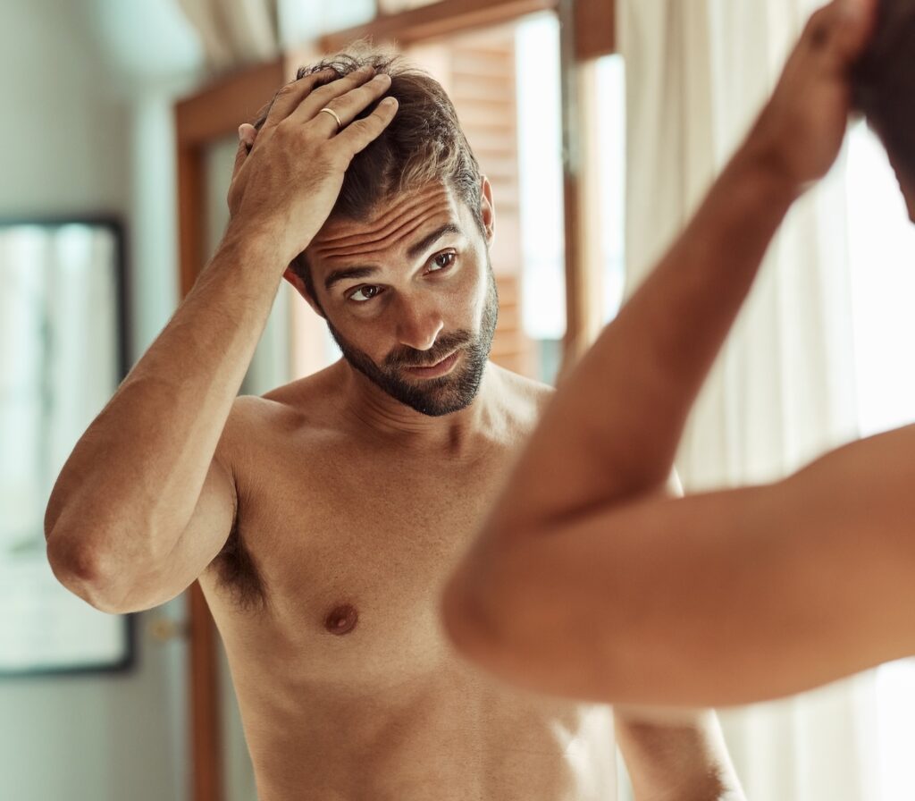 A man examines his results after hair loss treatment in Morris County, NJ