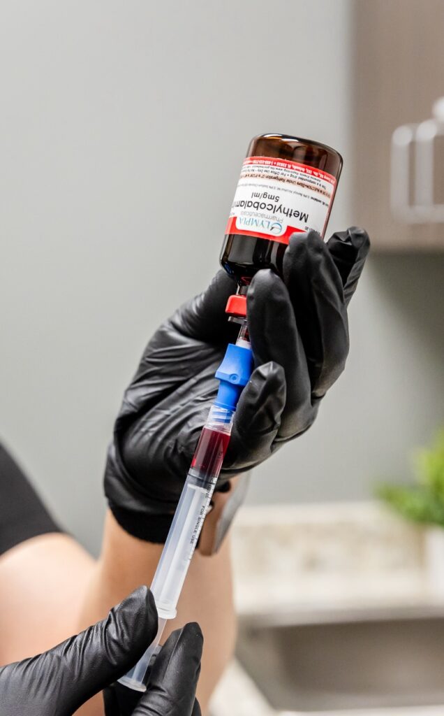 A provider wearing gloves prepares an injection for hormone optimization for men in Denville