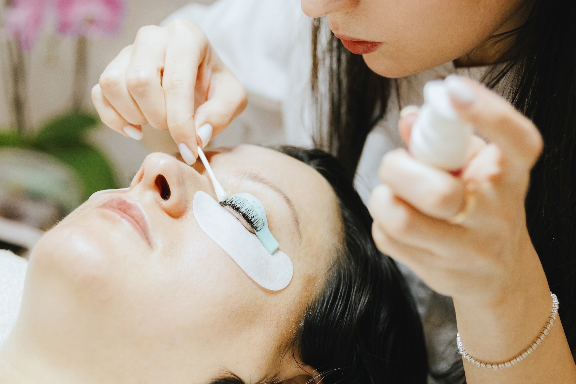 An aesthetician at Exhibit Medical Aesthetics moving around a female patient's eyelashes before providing a lash lift near Chatham, NJ.